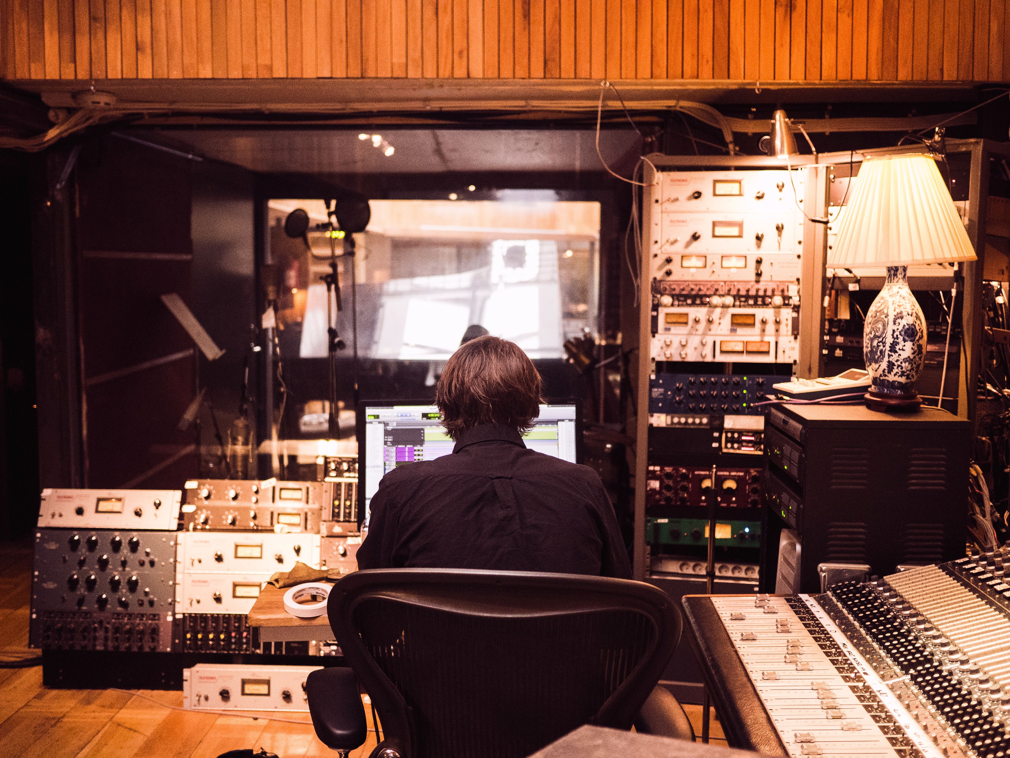 man in front of studio mixer and receiver